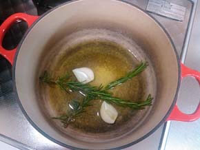 鍋にオリーブ油を注ぎ、ローズマリー、にんにくを入れる