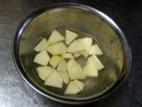 りんごをいちょう切りして塩水につける